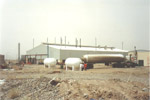 Process factory with large chemical storage tanks outside